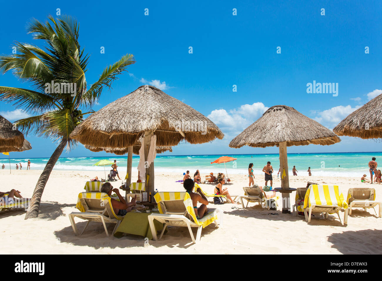 Le Mexique, Playa del Carmen personnes lors d'une plage avec des palmiers et des palapas Banque D'Images