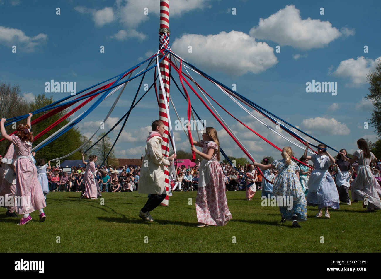 Peut Pole Dancing, Ickwell, Bedfordshire, Angleterre,mai 2013. Les enfants danser autour du mât sur la place du village à Ickwell. Banque D'Images