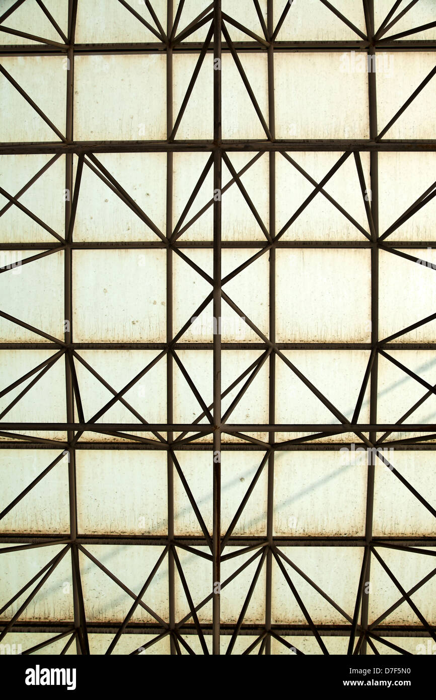 Détail de conception architecturale - résumé l'engrènement géométrique faite de tiges de métal et un peu jaunâtre sale verre. Banque D'Images