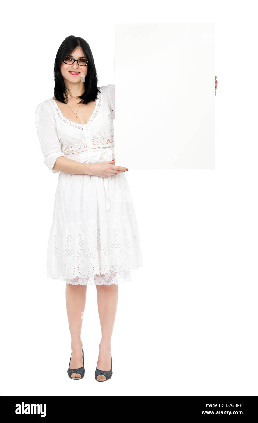 Un adulte (début 30's) black haired caucasian woman wearing jolie robe d'été blanche holding blank sign à côté d'elle tandis que Banque D'Images