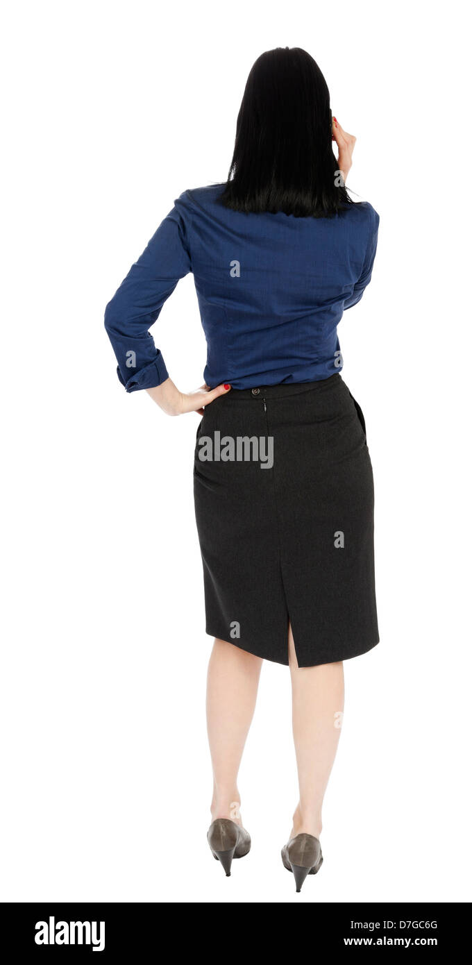 Un adulte (début 30's) black haired woman wearing blue chemisier boutonnée jupe gris foncé ; debout le dos à l'appareil photo Banque D'Images