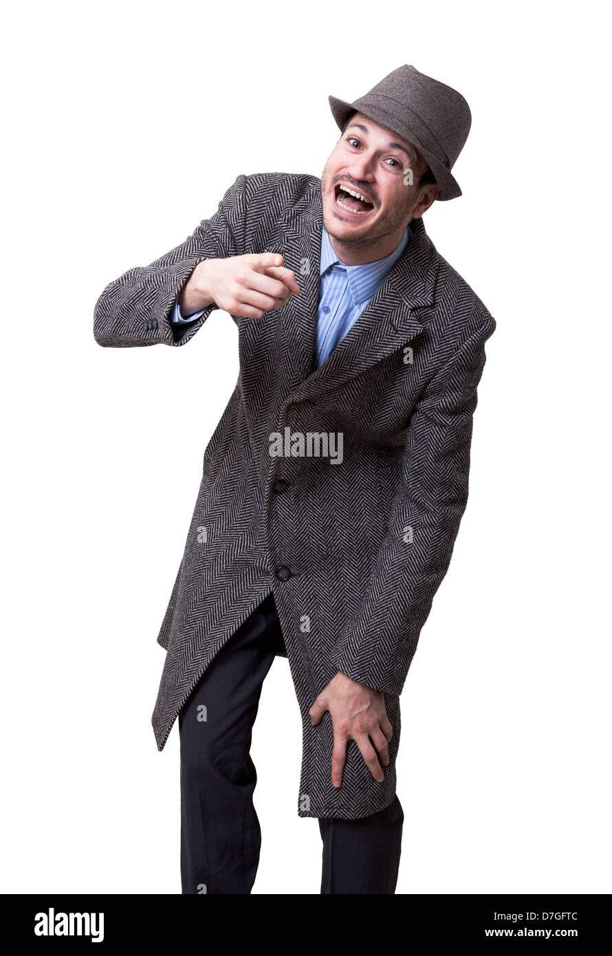 Un jeune homme adulte portant un manteau maching hat à la caméra pointant sur le rire éclatant. Isolé sur fond blanc. Banque D'Images