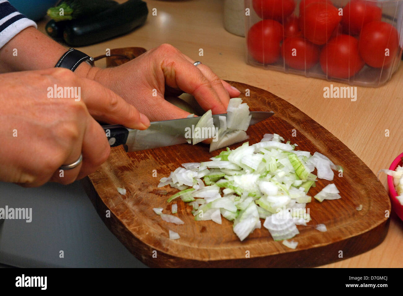 Travailler en cuisine, la préparation des aliments, les oignons de coupe Banque D'Images