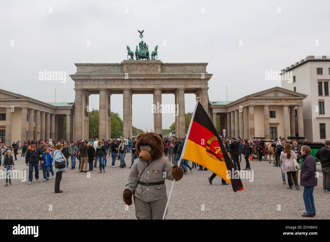 Quelqu'un vêtu d'un uniforme de l'Allemagne de l'Est et la tête d'un ours attendent les touristes de se faire photographier avec. Banque D'Images