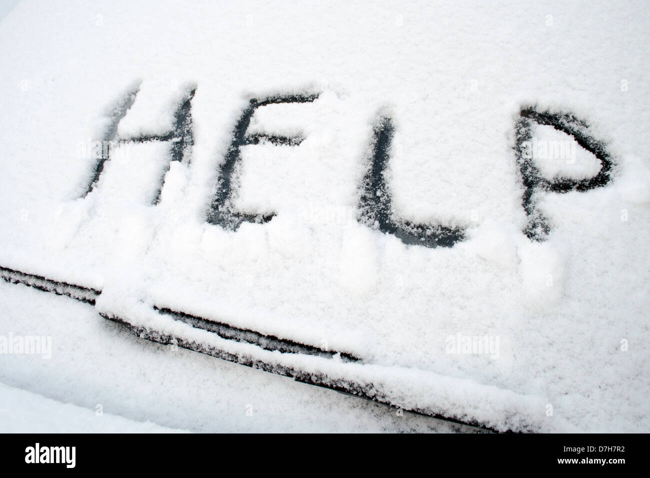 Aide mot écrit sur l'avant pare-brise de voiture couvert par neige mouillée Banque D'Images