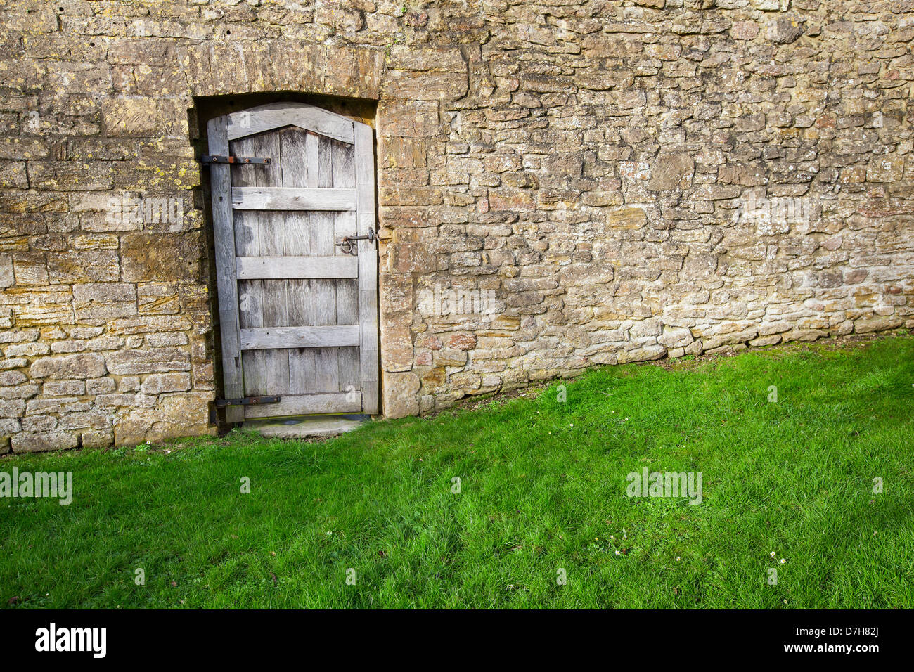 Vieille porte en bois dans un grand jardin en pierre mur Banque D'Images