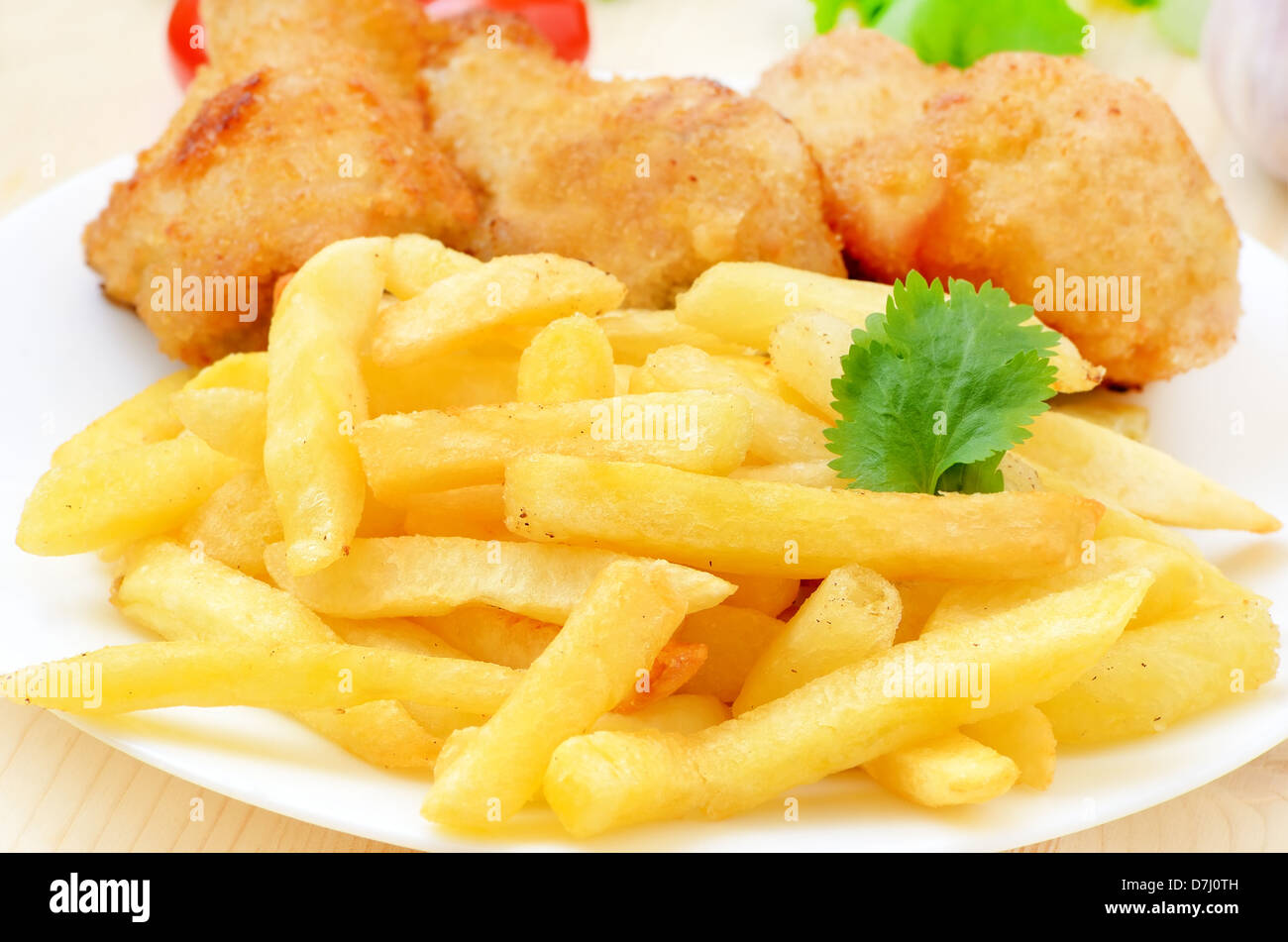 Frites avec du poulet frit sur une plaque blanche Banque D'Images