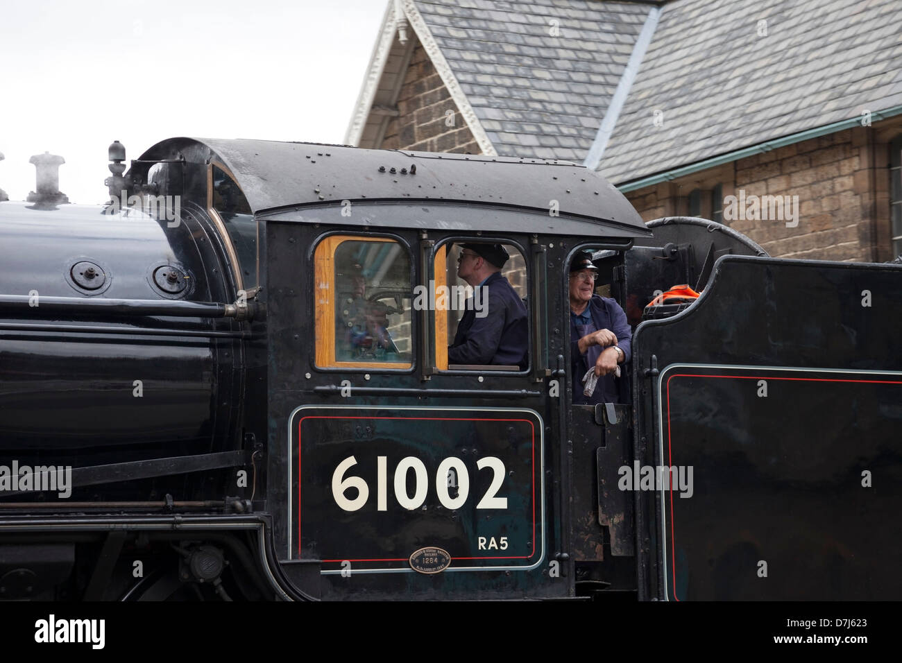 Membre de l'équipage à la recherche hors de la Locomotive à vapeur 61002 Impala lorsqu'il quitte la station de Grosmont NYMR Yorkshire Angleterre UK Banque D'Images