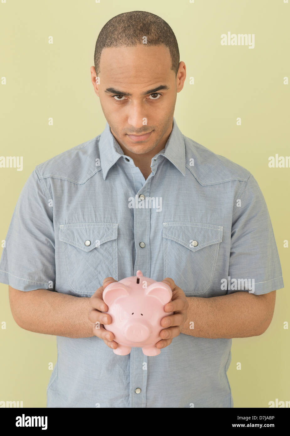 Young man holding piggy bank Banque D'Images