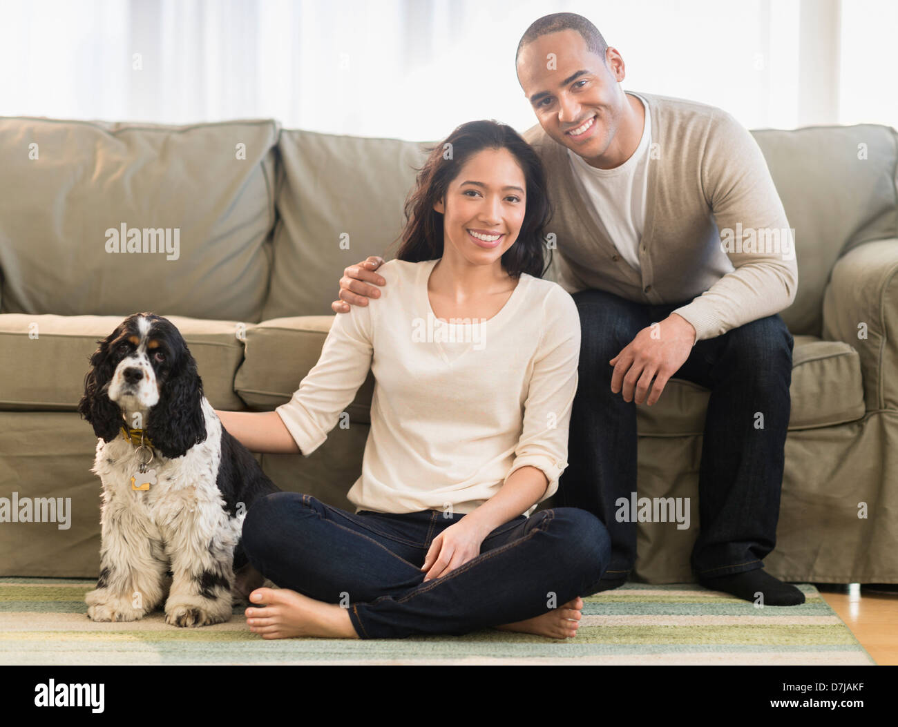 Jeune couple avec chien dans la salle de séjour Banque D'Images