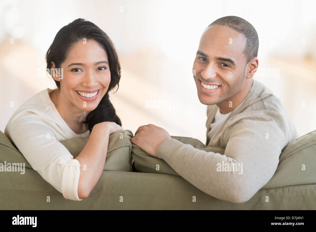 Portrait of young couple sitting on couch Banque D'Images