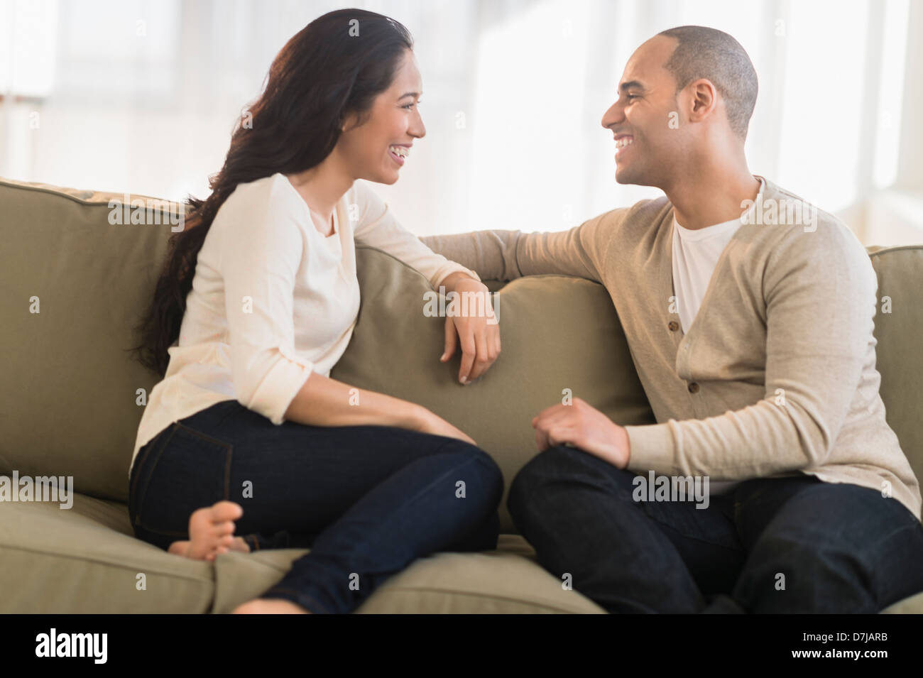 Portrait of young couple sitting on couch Banque D'Images