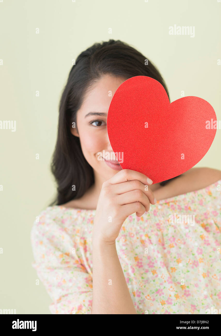 Jeune femme tenant papier rouge coeur Banque D'Images