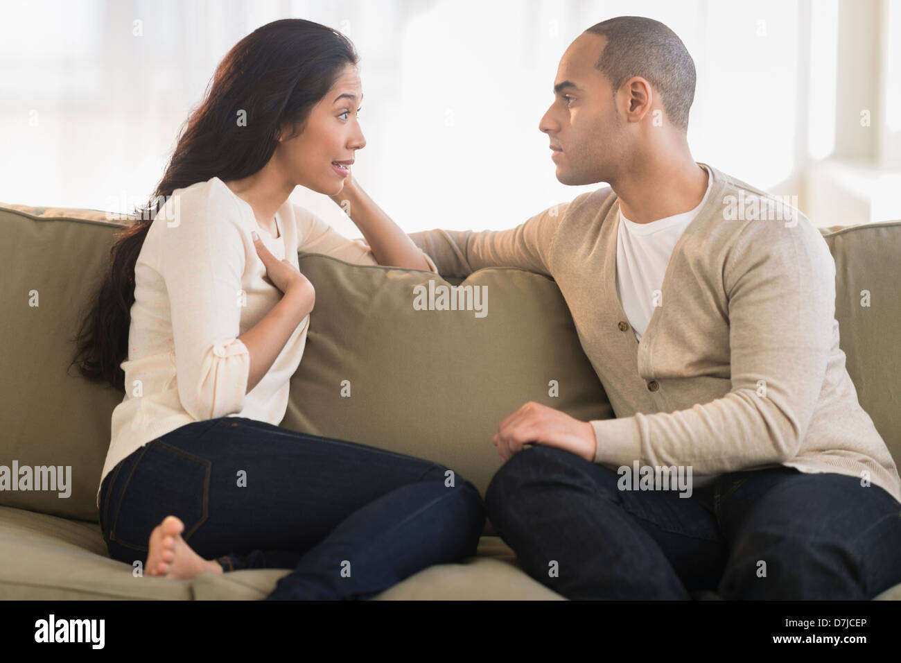 Young couple sitting on couch Banque D'Images