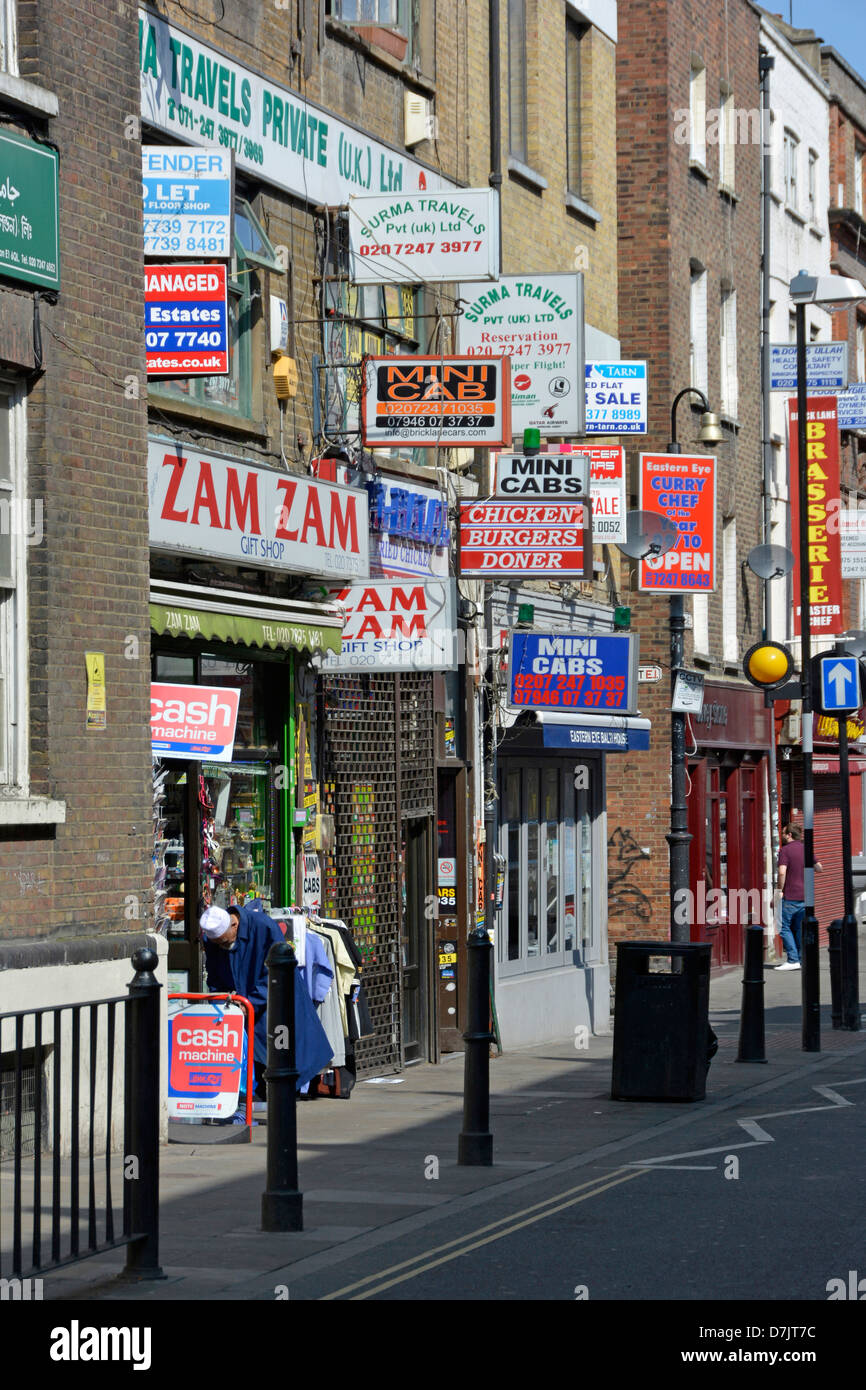 Les enseignes en concurrence pour l'espace le long Brick Lane Tower Hamlets East London England UK Banque D'Images