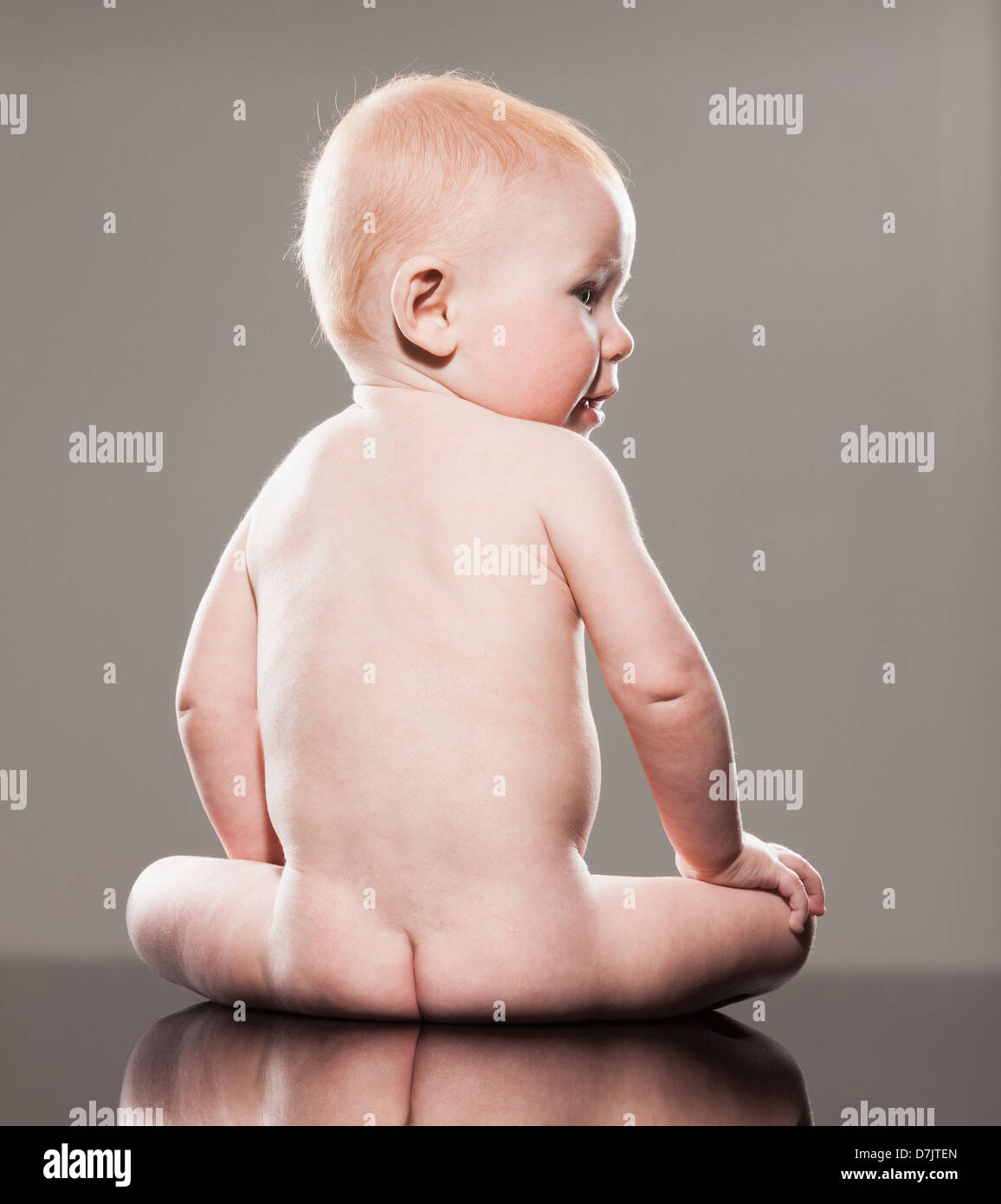 Studio shot of naked baby boy (18-23 mois) looking over shoulder Banque D'Images