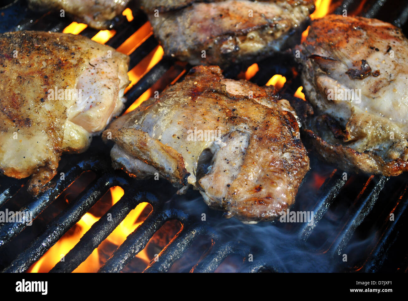 Griller le poulet avec des flammes Banque D'Images