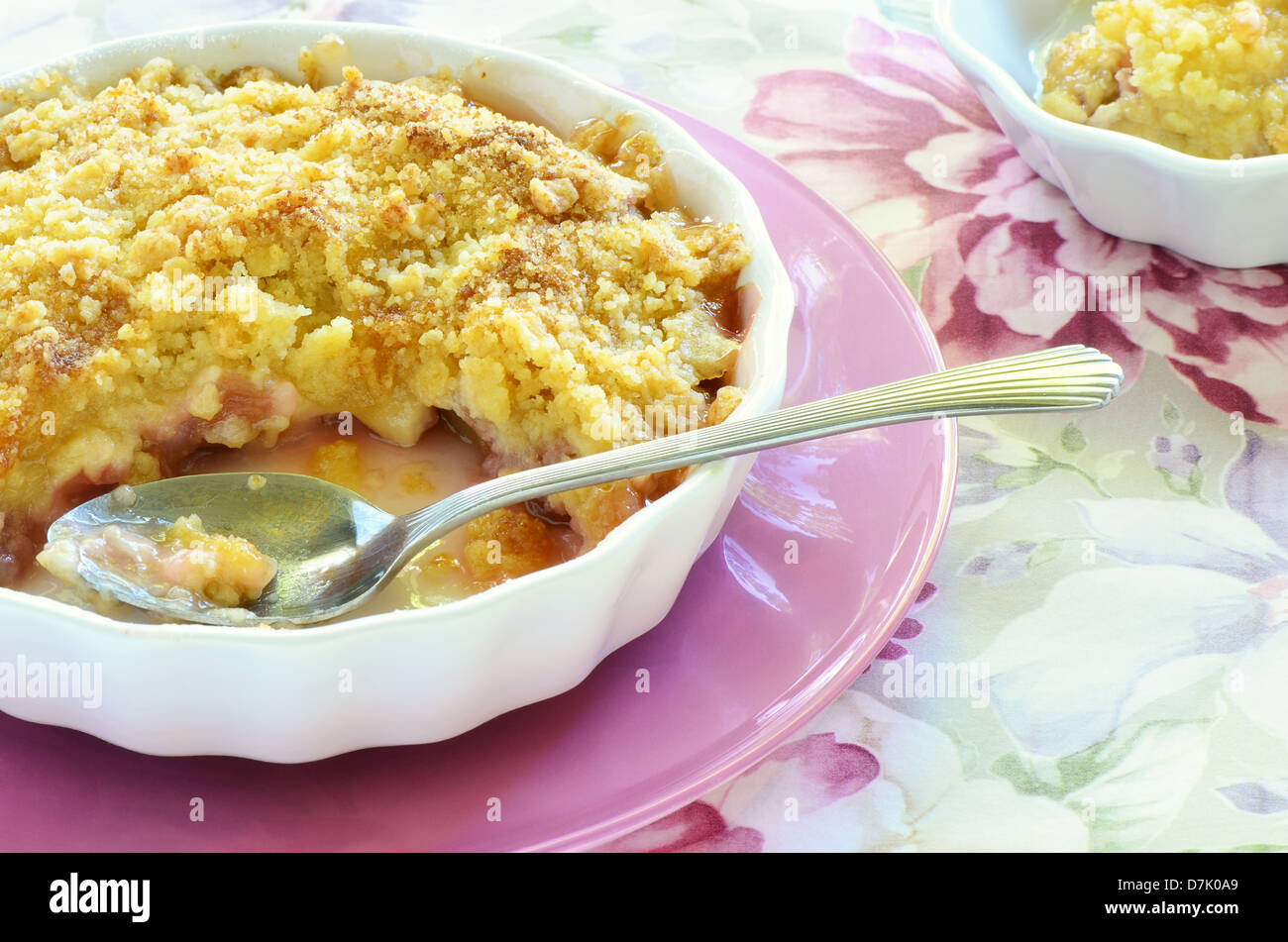 Crumble rhubarbe à l'ancienne dans un plat blanc avec cuillère Banque D'Images
