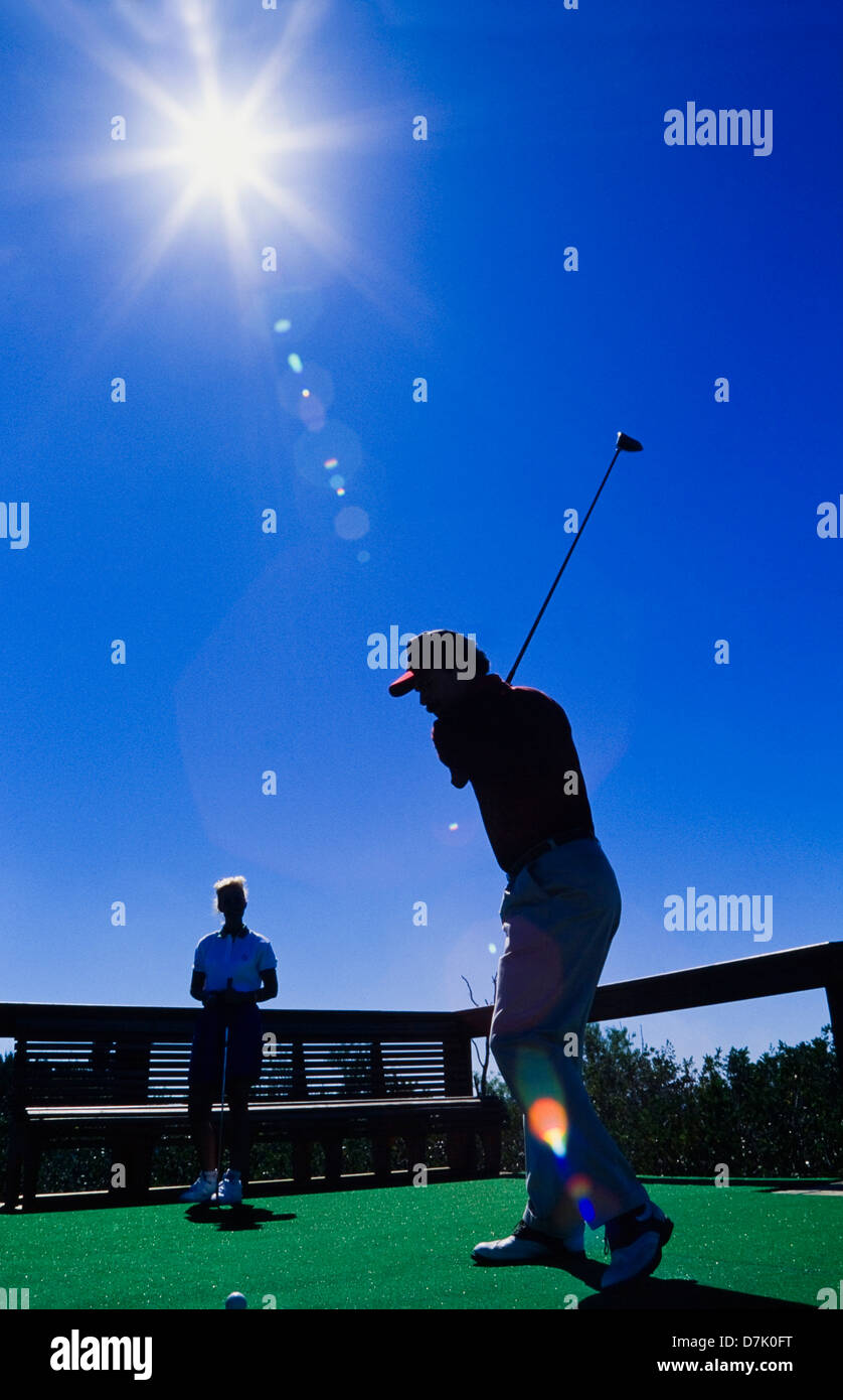 Couple playing golf, Male golfer hitting ball, Miami Banque D'Images