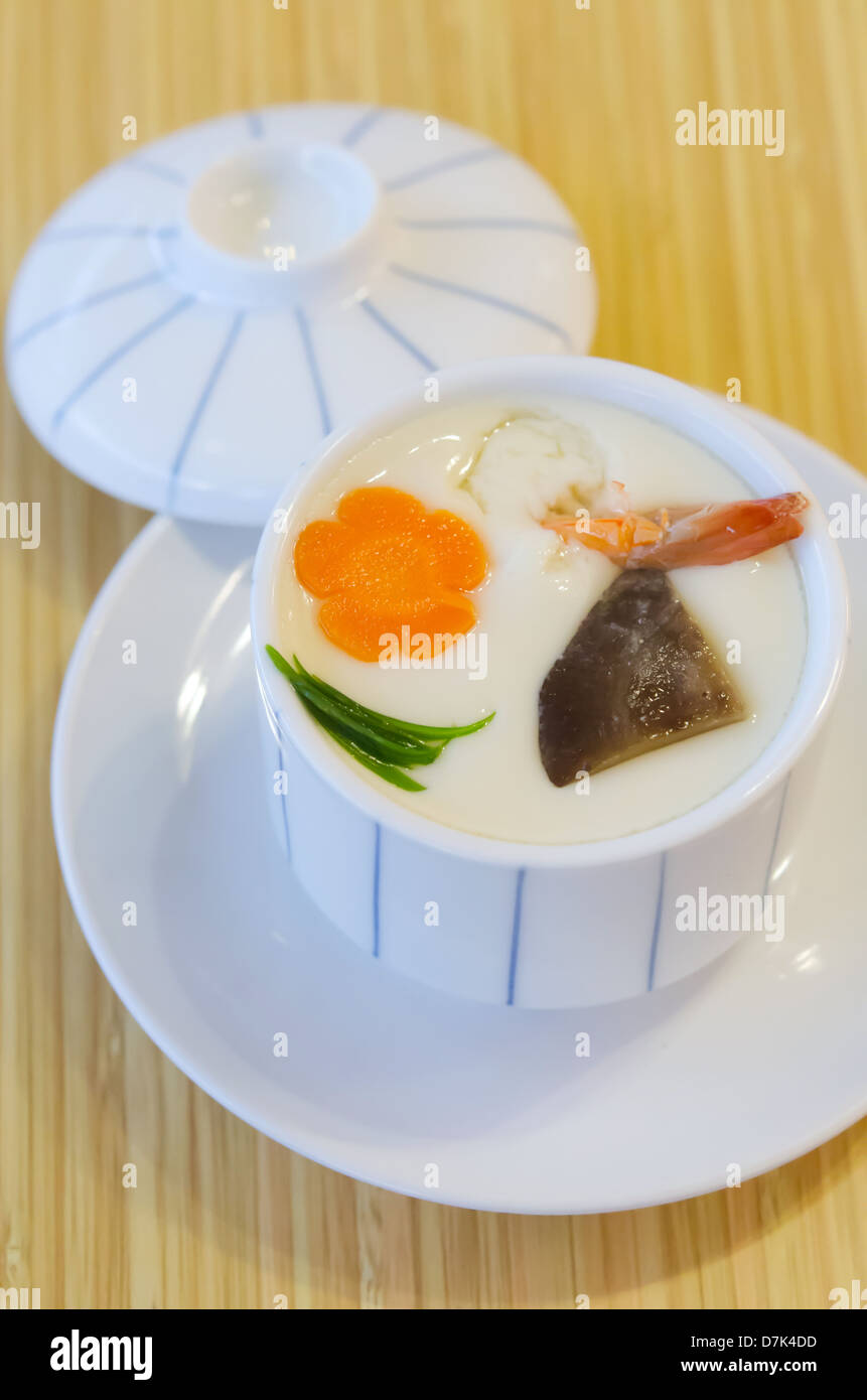 Oeufs à la vapeur avec de la viande et légumes dans un bol blanc sur fond de bois Banque D'Images