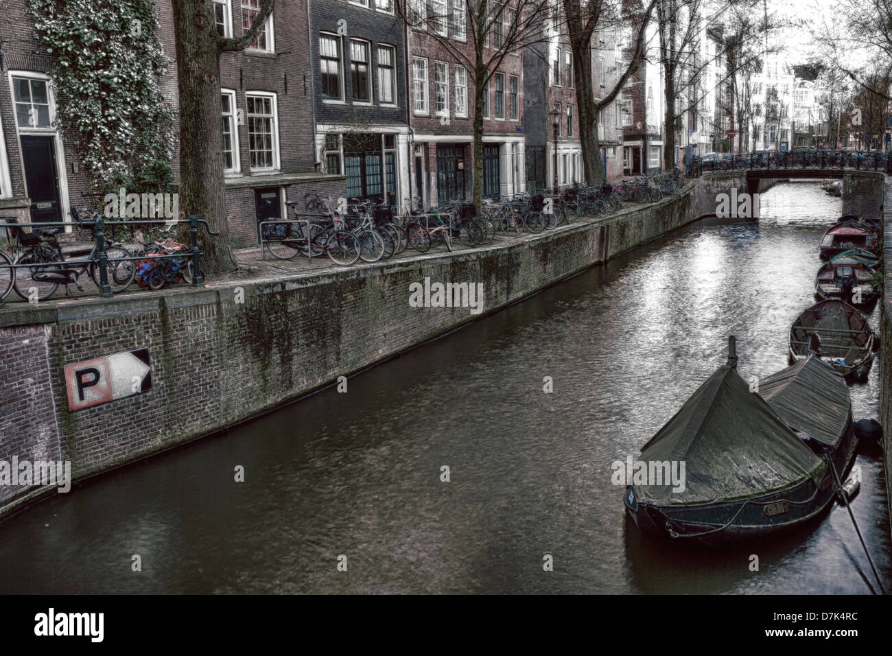 Un canal de la ville d'Amsterdam avec beaucoup de vélos et des bateaux Banque D'Images