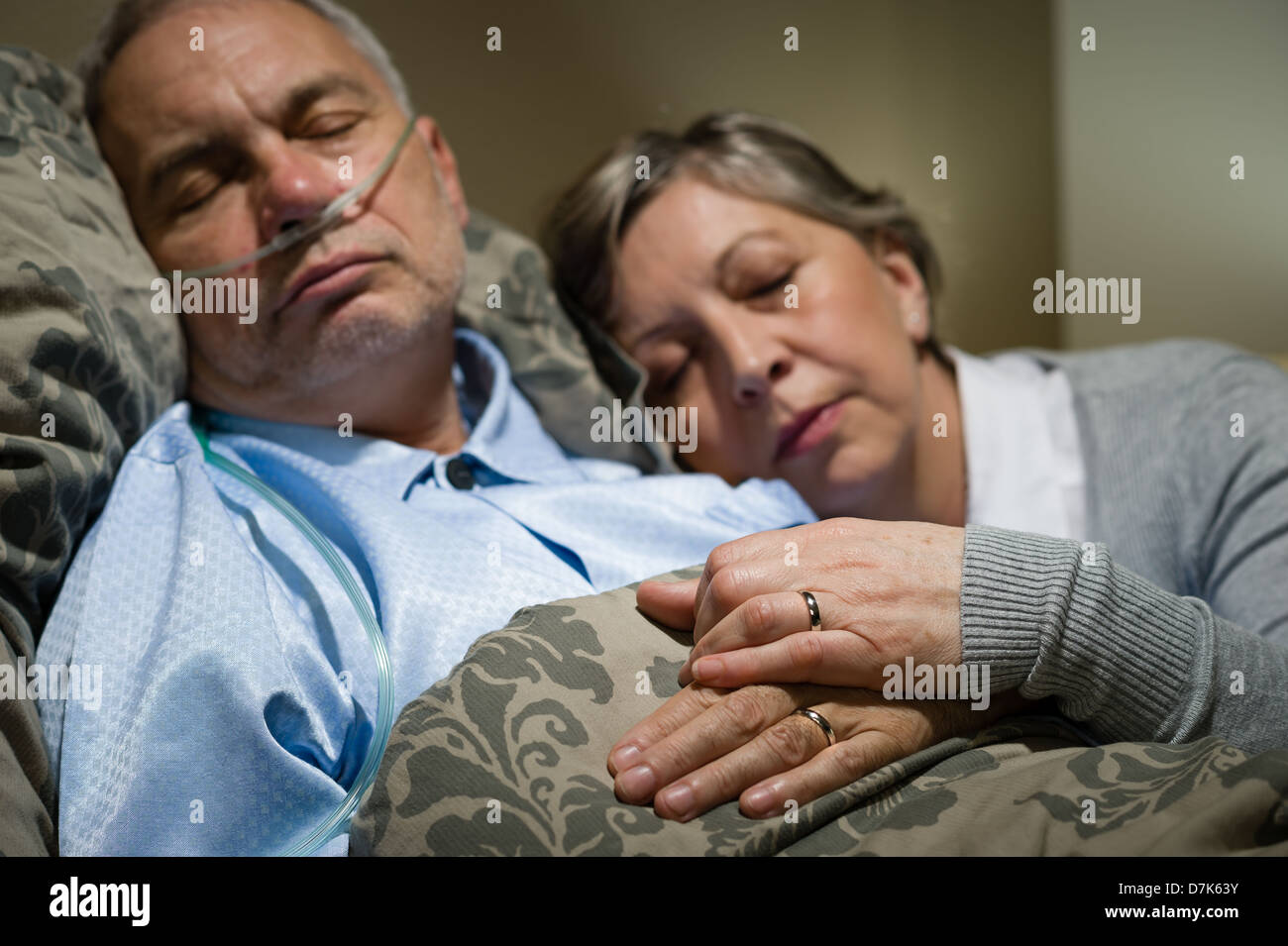 Vieux couple dormir ensemble au lit avec l'homme de la canule nasale Banque D'Images