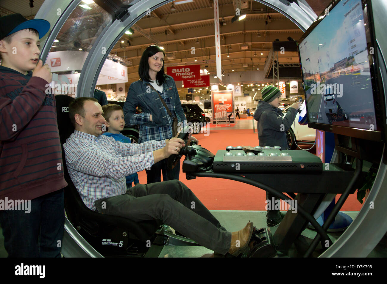 Poznan, Pologne, les visiteurs dans un simulateur de conduite à la Motor Show 2013 Banque D'Images