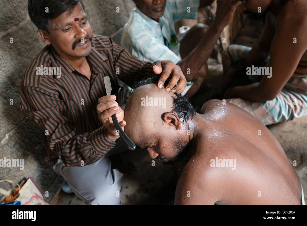 Un dévot hindou a sa tête rasée en échange d'une bonne santé à l'Arunachaleswara Temple à Tiruvannamalai, Tamil Nadu, Inde Banque D'Images
