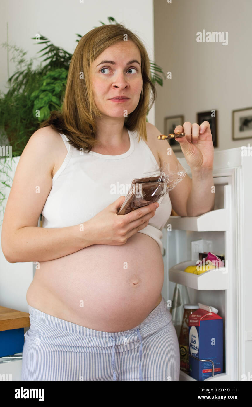 Allemagne, Hesse, Francfort, pregnant woman eating chocolate Banque D'Images