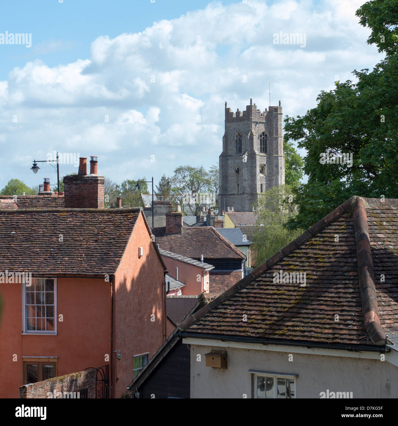 La tour de l'église de Saint tous à Sudbury, Suffolk, Angleterre, avec de vieux toits de maison au premier plan. Banque D'Images