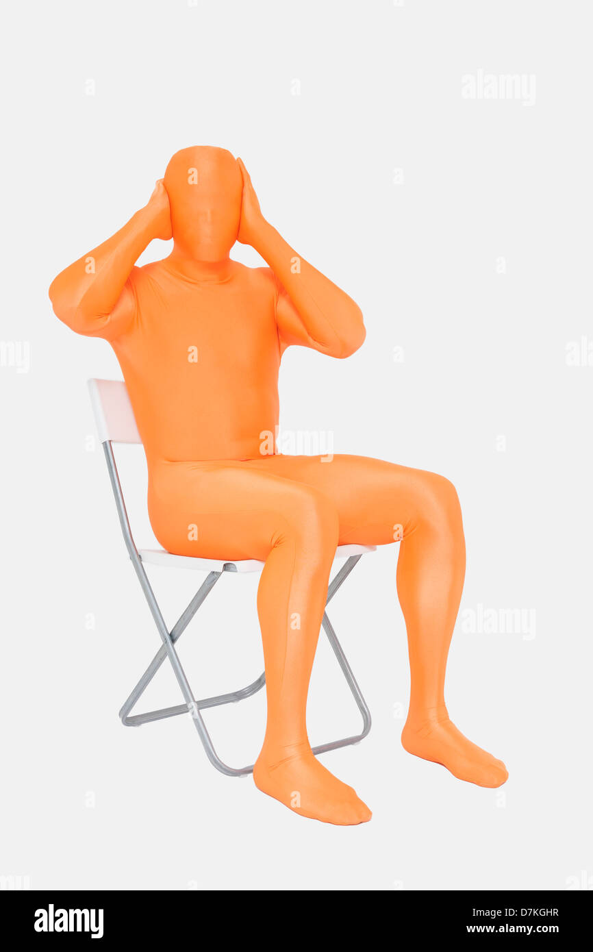 Homme mûr en orange zentai avec mains couvrant les oreilles Banque D'Images