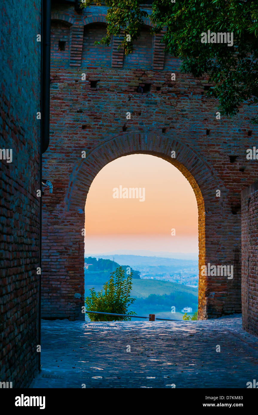 Un coucher de soleil vu à travers une arche de la ville médiévale de Gradara en Italie Banque D'Images
