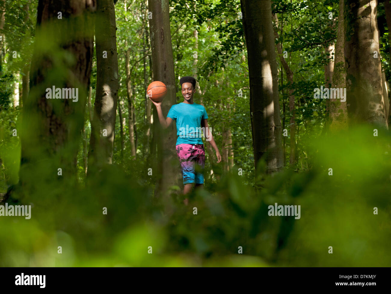 Jeune homme noir jouant au basket-ball dans les bois Banque D'Images