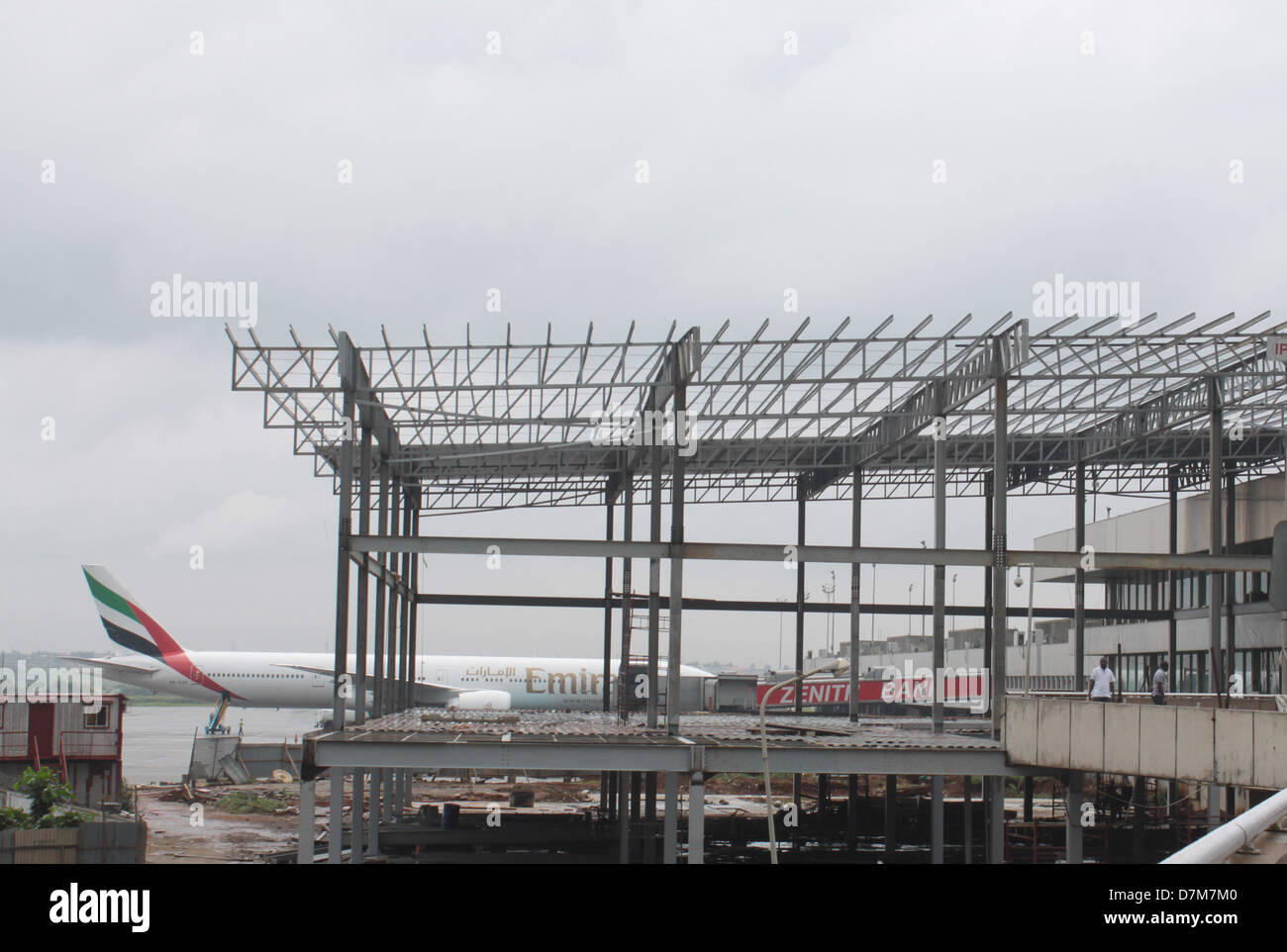 Un aéronef stationné sur la E doigt de l'aéroport Murtala Muhammed de Lagos, pans contre la construction en cours de skeleton. Banque D'Images