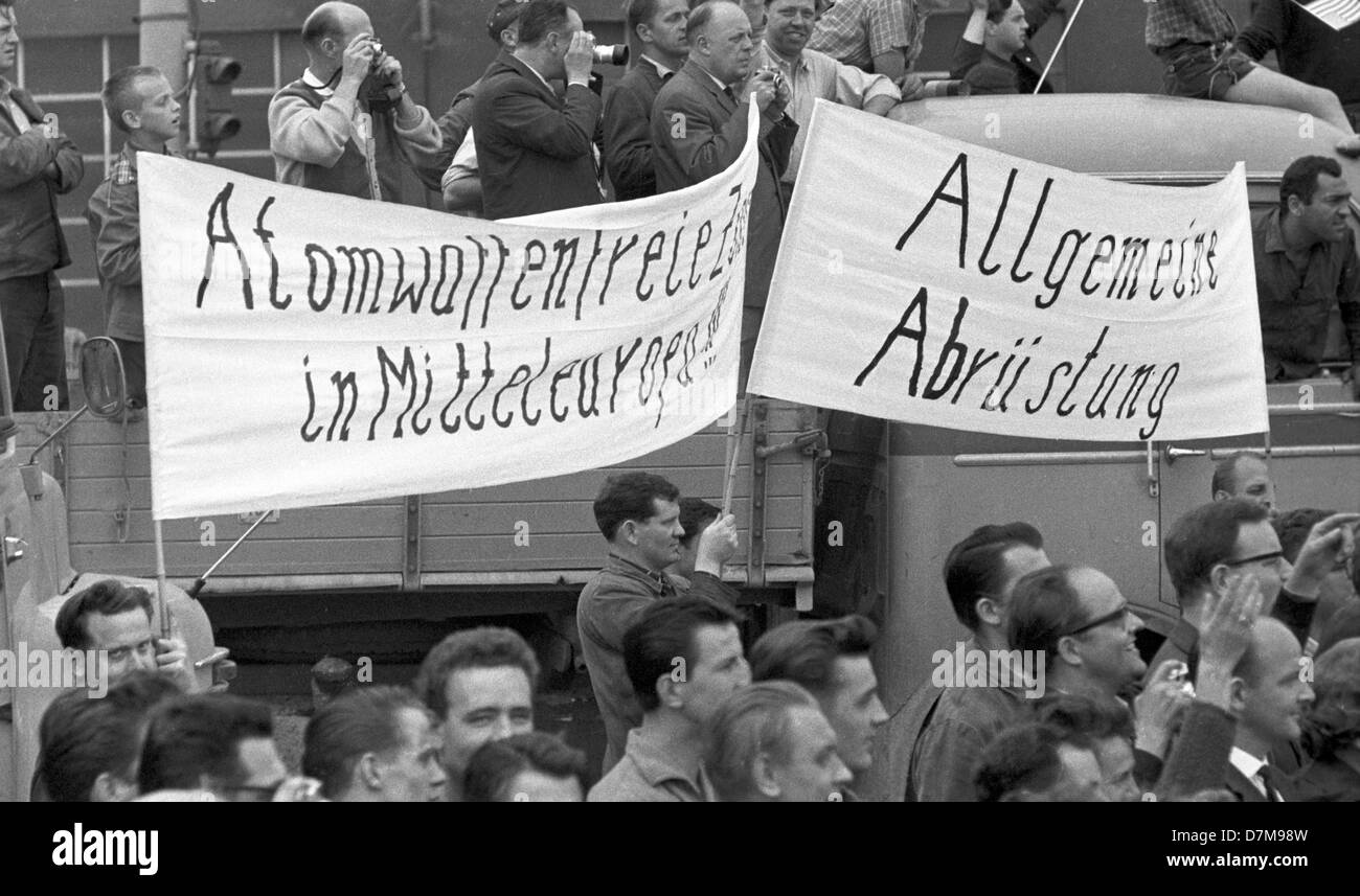 Les manifestants exigeant le désarmement. Après avoir visité un défilé militaire de l'OTAN à base d'air Langendiebach à Hanau le 25 juin 1963 a conduit à un JFK limousine de Hanau à Francfort accompagné par le vice-chancelier Ludwig Erhard et premier ministre d'état de Hesse Zinn. Banque D'Images