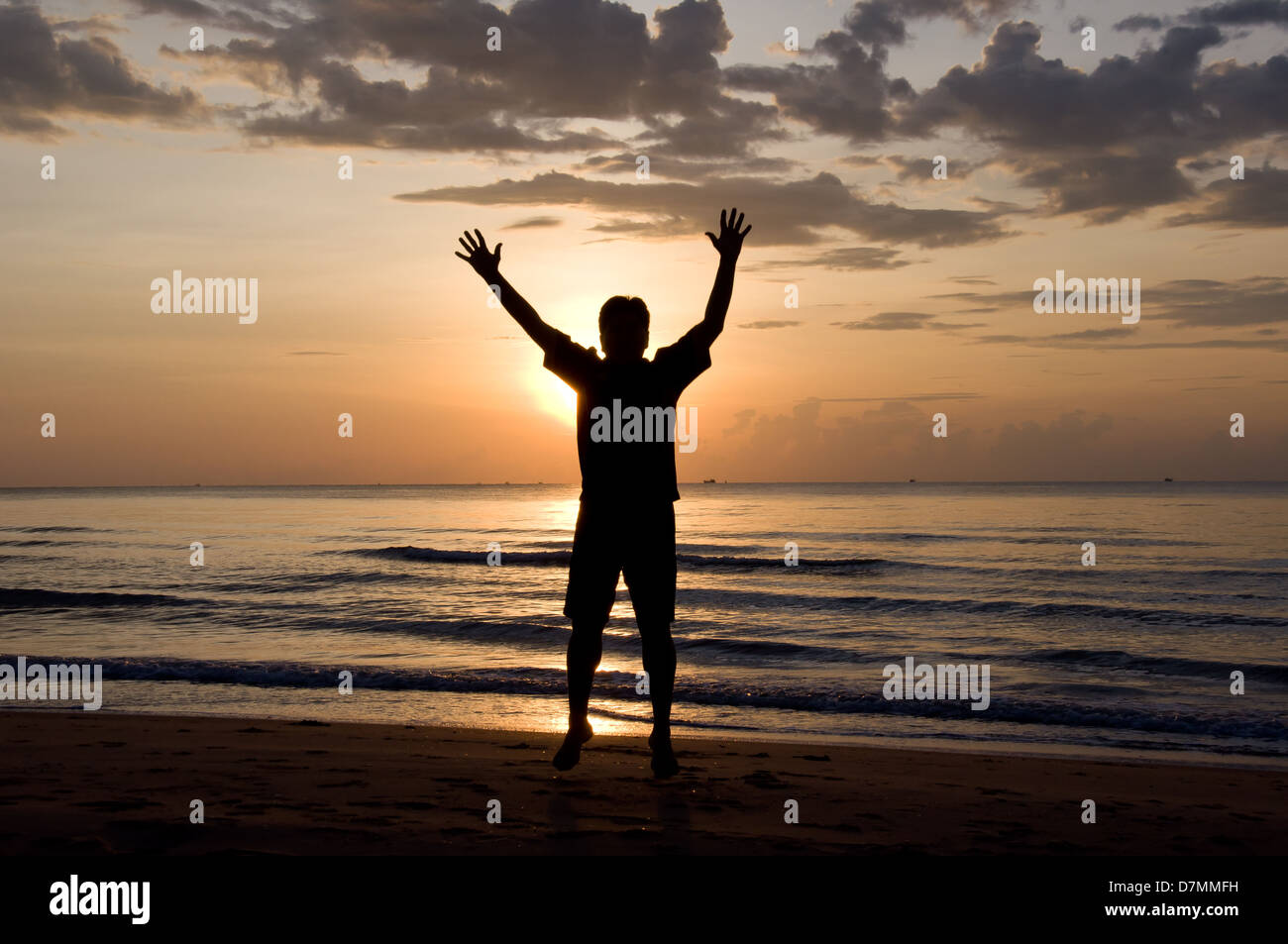 Silhouette de se sentir libre et heureux homme sur la plage Banque D'Images