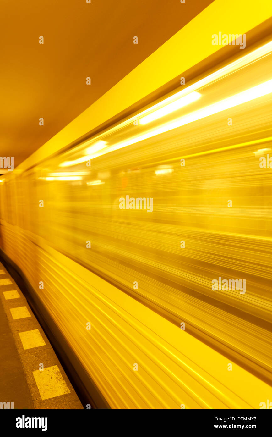 A fast moving train souterrain de couleur jaune Berlin quitte la gare à grande vitesse de créer l'effet de flou. Banque D'Images