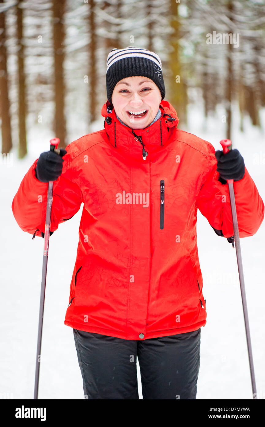 Happy girl posing en skis dans la forêt d'hiver. Banque D'Images