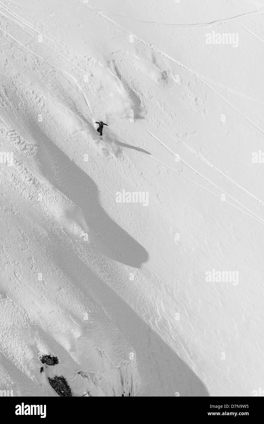 Snowboarder juste sauté une petite falaise Banque D'Images