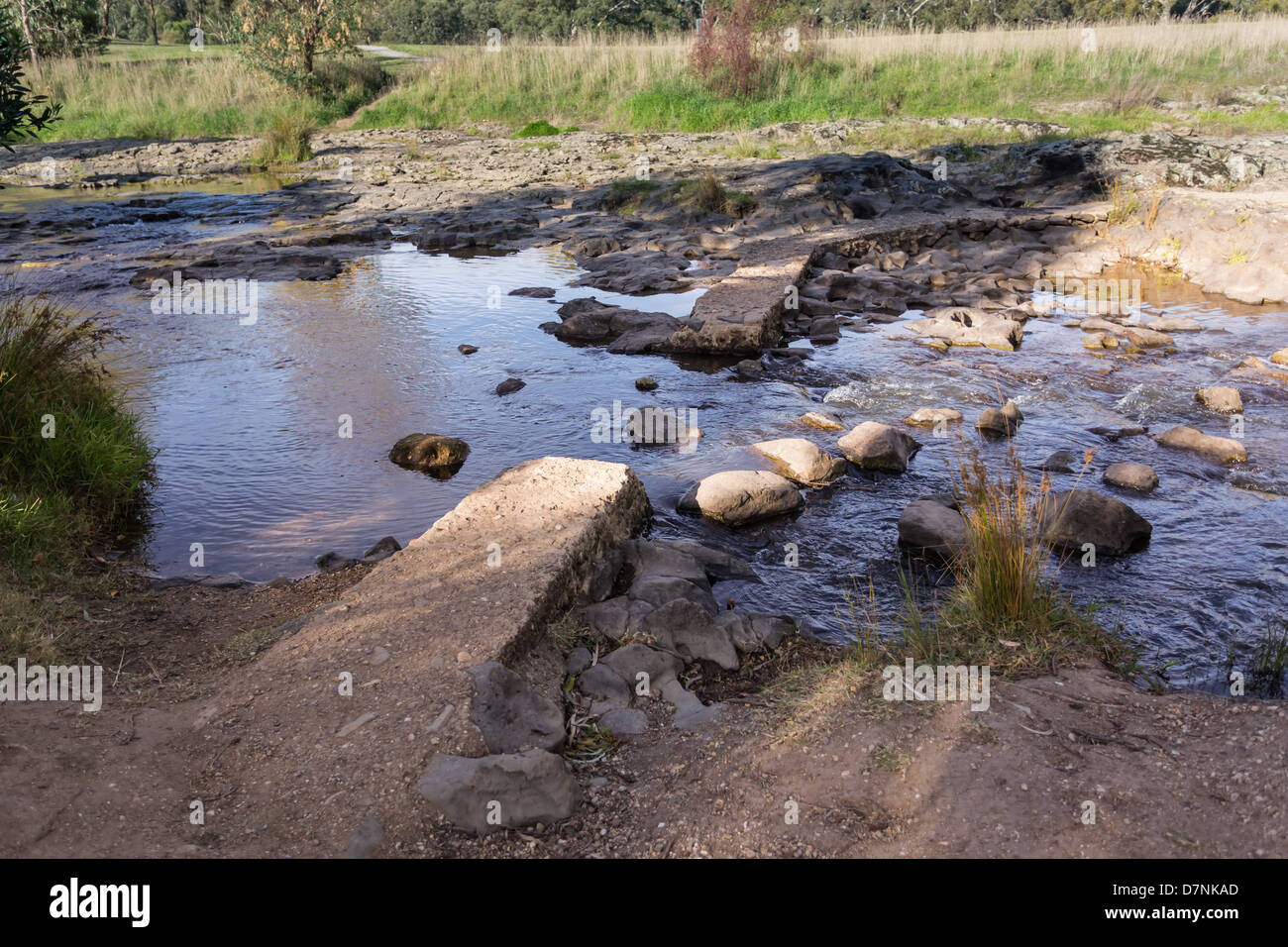 Le ruisseau paisible qui s'écoule sur les pierres avec un barrage miniature. Banque D'Images