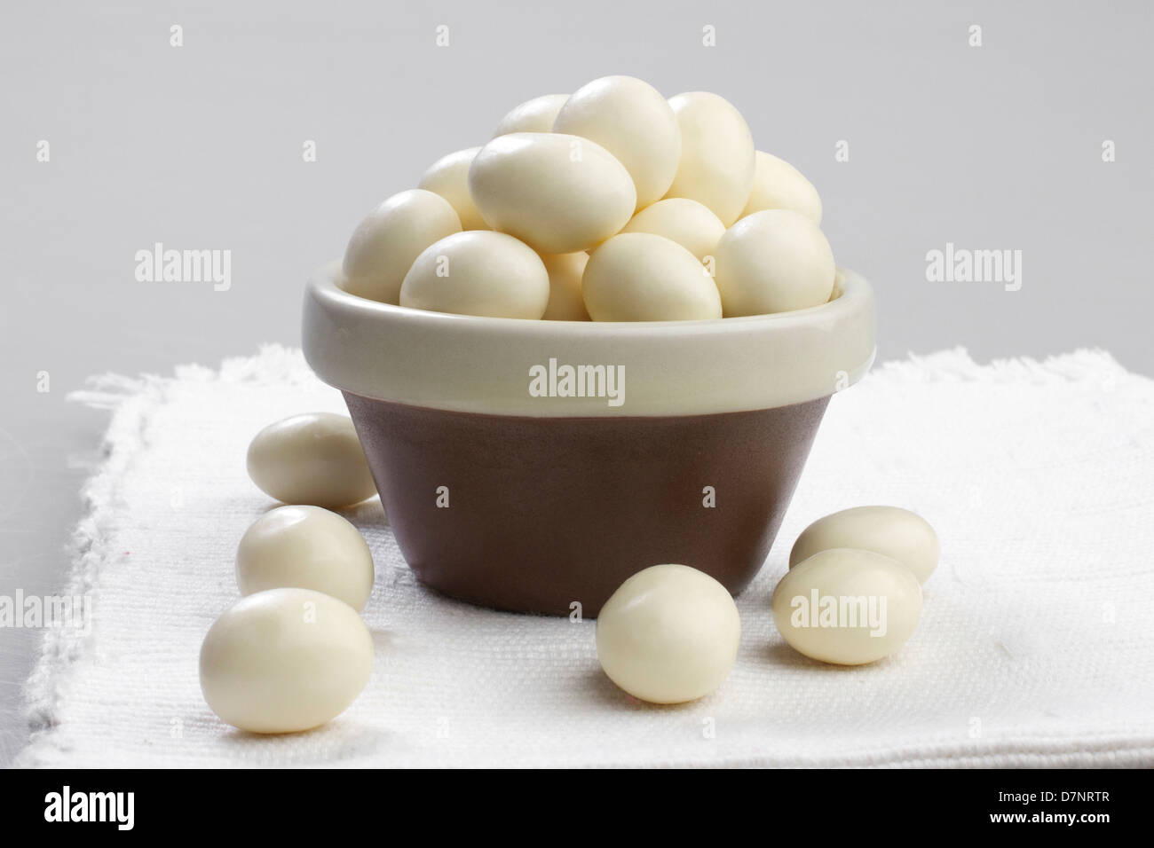 Arachides enrobées de chocolat blanc dans un bol Banque D'Images