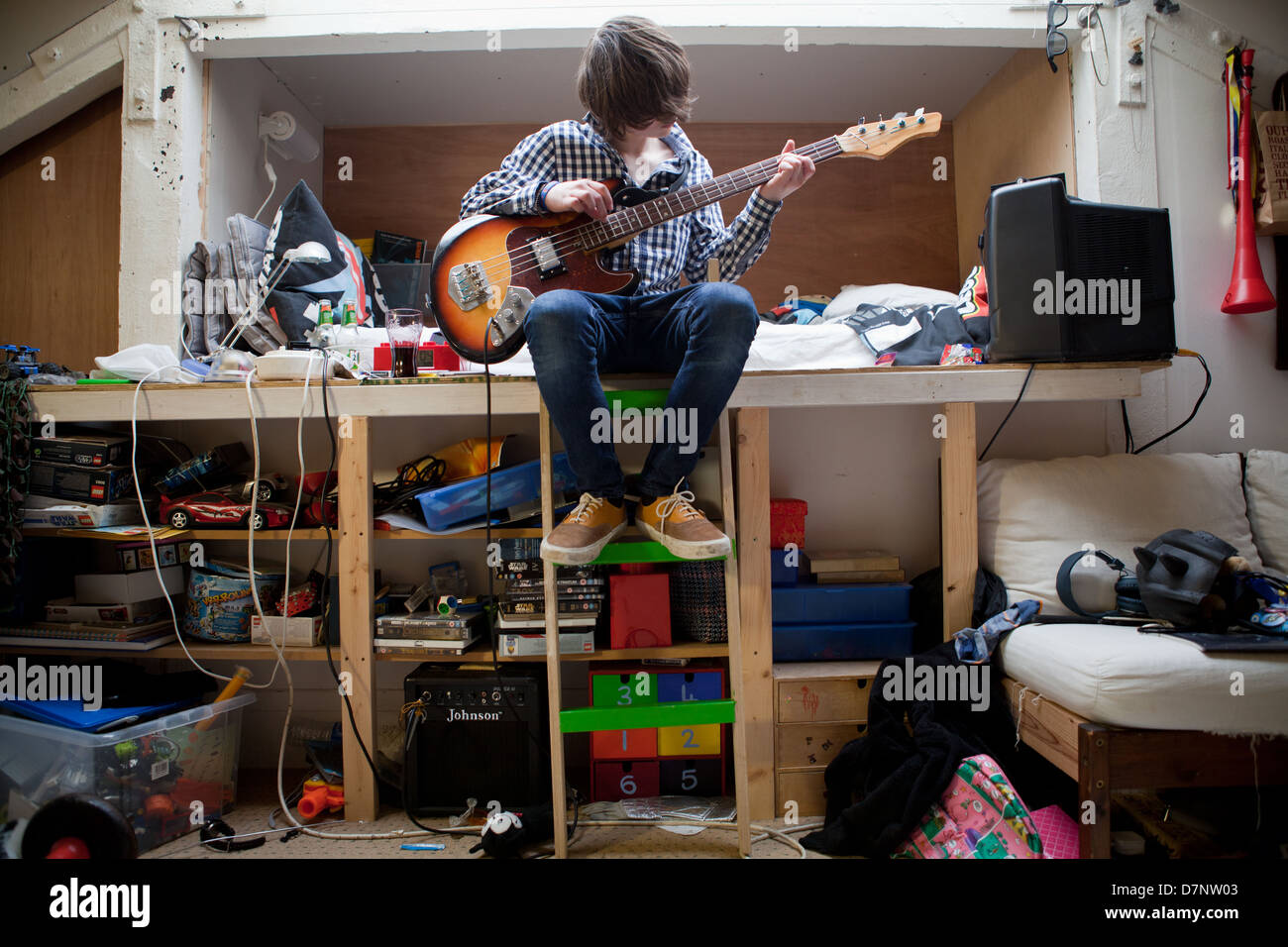 Un adolescent joue de la guitare basse dans sa chambre à coucher Photo  Stock - Alamy