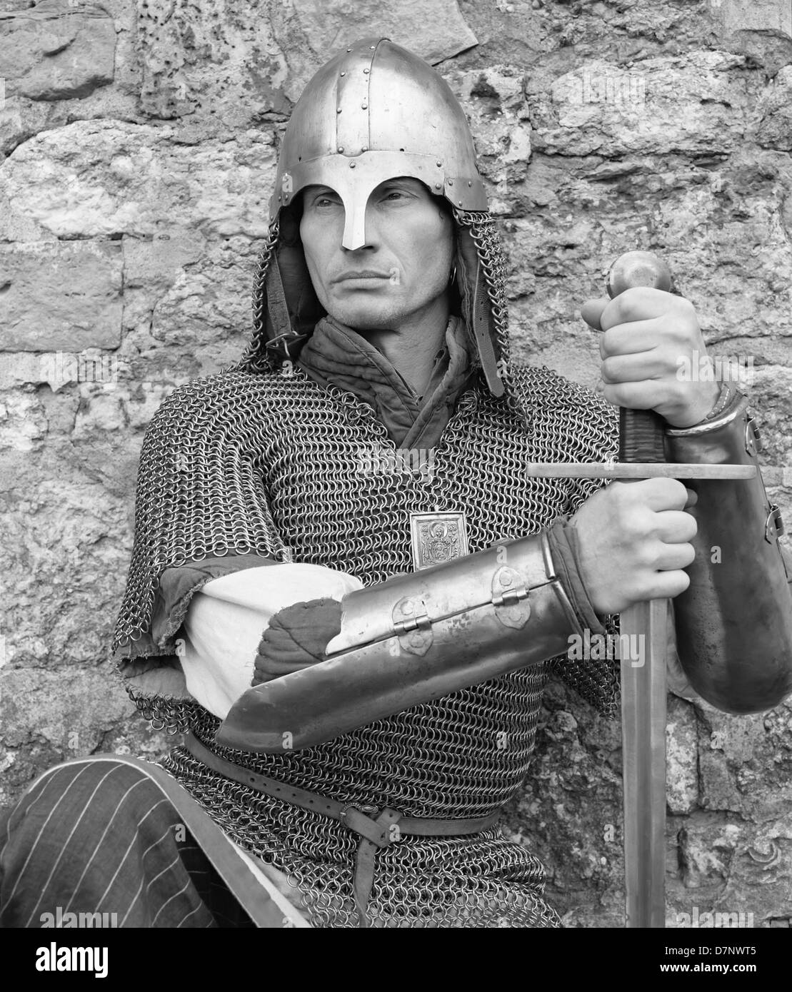 Fédération de l'homme en armure avec une épée contre le mur de pierres Banque D'Images