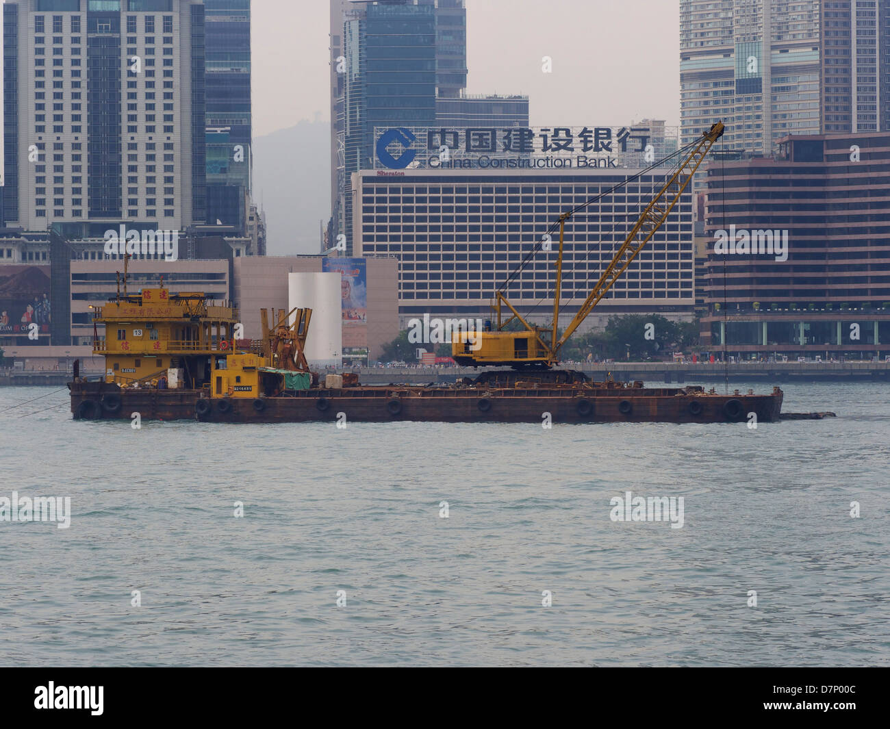 Une barge de l'équipement de construction à travers le port de hong kong Banque D'Images