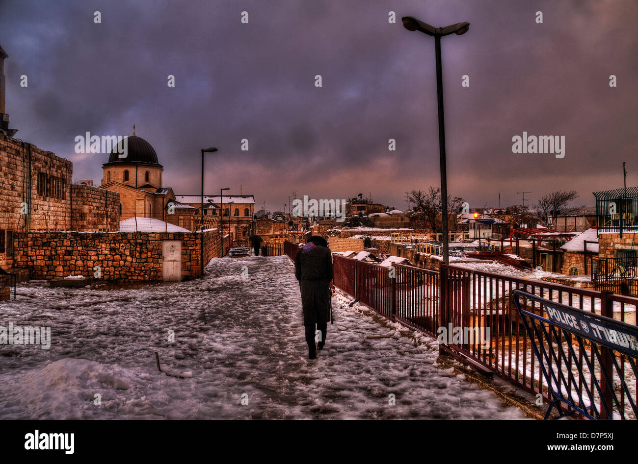 Juif orthodoxe homme marchant dans les toits enneigés chemin de Jérusalem Vieille ville Banque D'Images