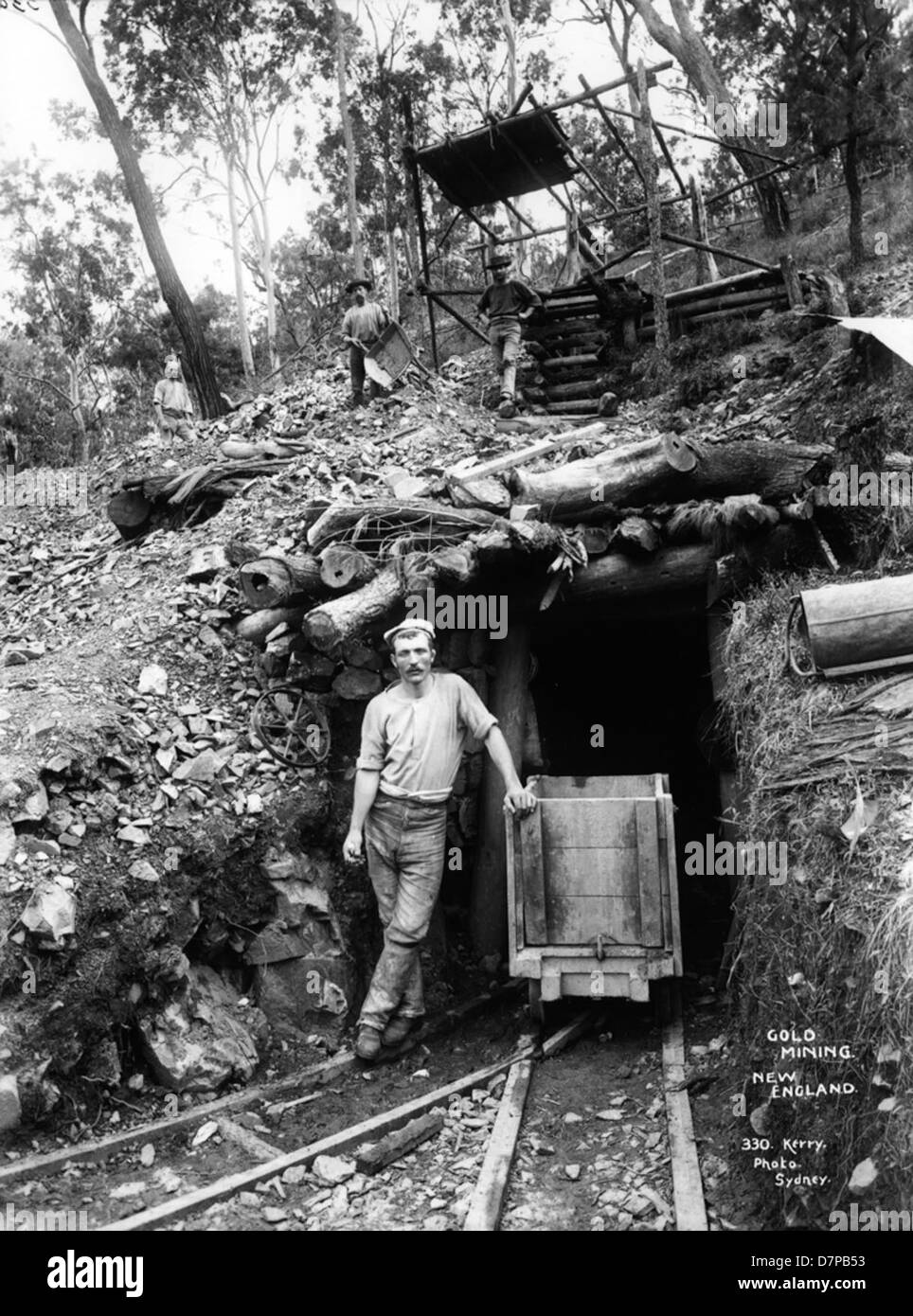 Cette photographie en noir et blanc présente les opérations d'extraction d'or en Nouvelle-Angleterre, capturant le processus minier exigeant en main-d'œuvre, y compris les mineurs au travail et l'infrastructure minière. Banque D'Images