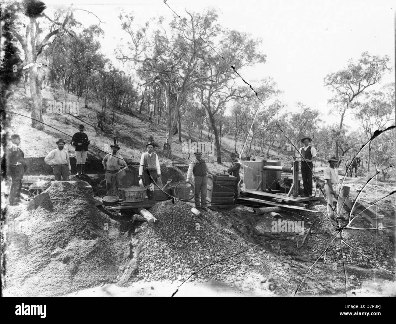 Cette photographie en noir et blanc de l'ère de la ruée vers l'or montre neuf hommes cherchant de l'or, capturant le grain et la détermination des mineurs pendant la ruée vers l'or en Californie. Banque D'Images