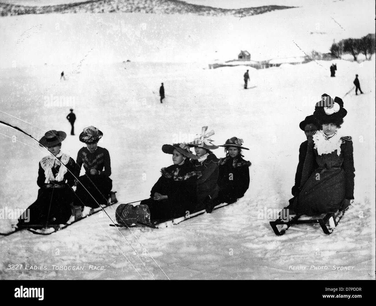 Négatif noir et blanc sur plaque de verre de 1900 montrant une course de luge féminine avec des participantes comme Ada Pattinson, Agnes Eastwood et Amy Pattinson. L'image capture l'excitation de la course et la mode du début du XXe siècle des athlètes. Banque D'Images