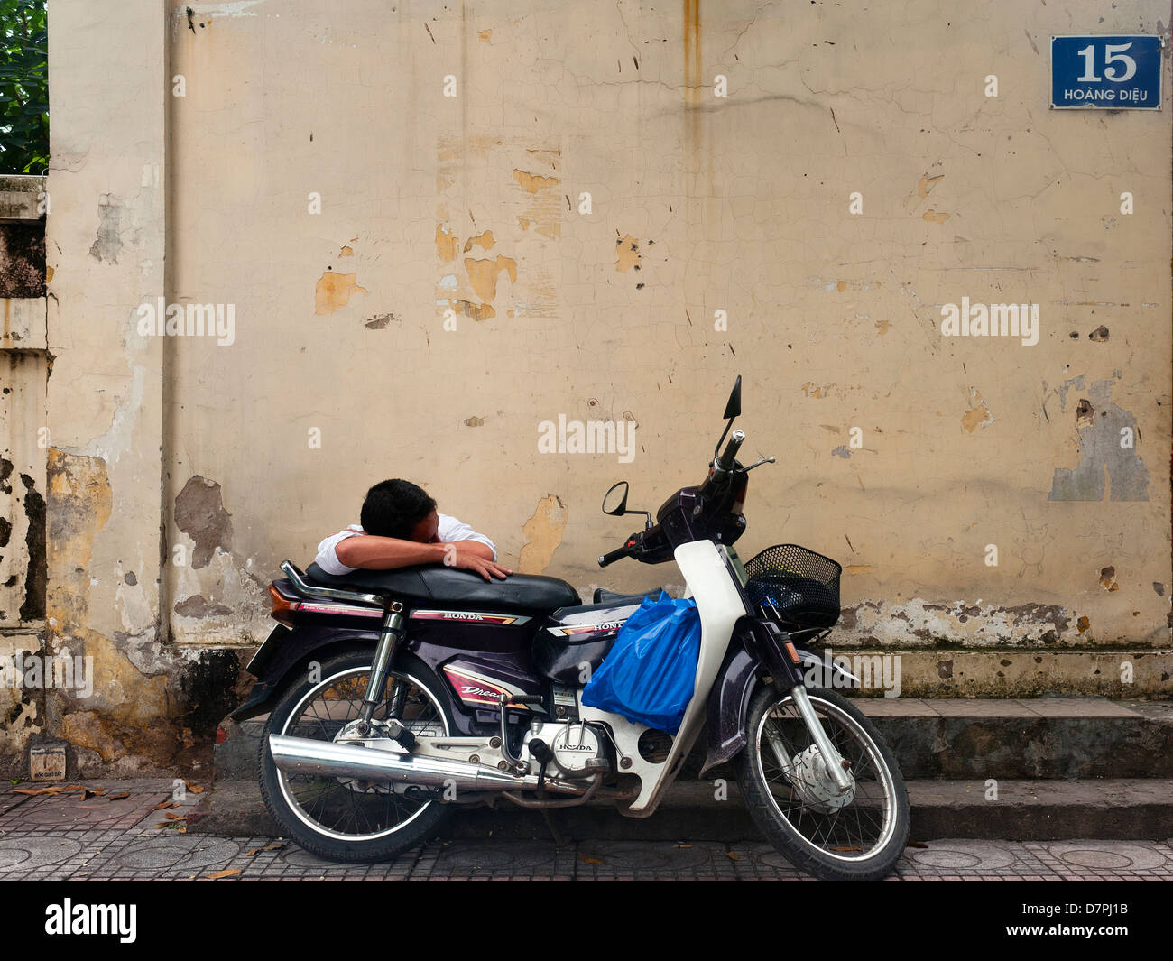 Hanoi Vietnam - Homme dormir sur cyclomoteur Banque D'Images