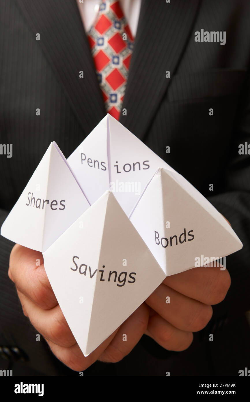 Business man holding origami papier Fortune Teller avec les obligations d'épargne,actions,et pensions écrit dessus Banque D'Images